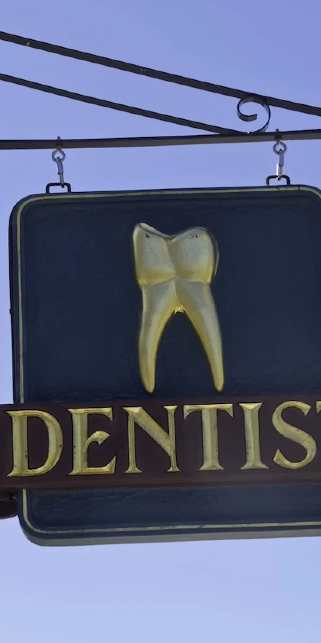 dentist-s-sign-with-gold-tooth-against-a-blue-sky-2026-01-09-14-49-55-utc